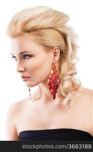 sensual portrait of very attractive blond woman with creative hair style and big fashion red earring with black top, she is turned three quarters and looks in front of her