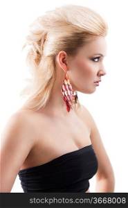 sensual portrait of very attractive blond woman with creative hair style and big fashion red earring with black top, she is positioned in profile and looks at the left in front of her