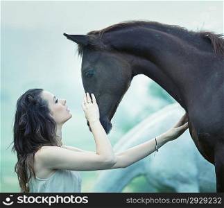 Sensual woman stroking a wild horse