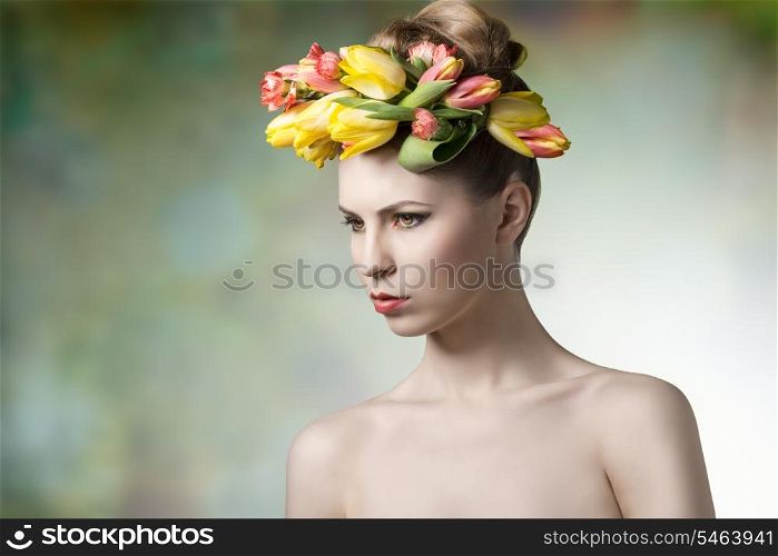 sensual young girl posing in spring portrait with floral wreath on her head, naked shoulders and fresh colorful make-up