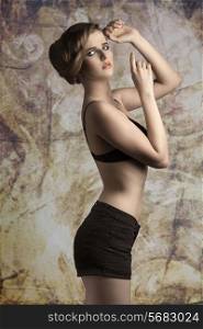 sensual young girl wearing black bra and shorts, in fashion pose with elegant hair-style and stylish make-up