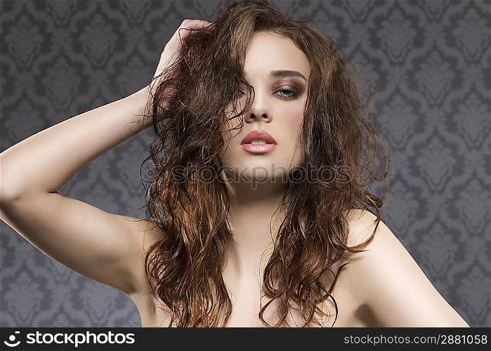 sensual young girl with brown hair, wavy wet hair-style and cute make-up, looking in camera with sexy expression on vintage background