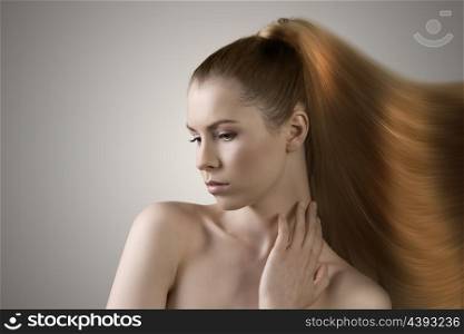 sensual young girl with naked shoulders and long blonde hair melting in paint