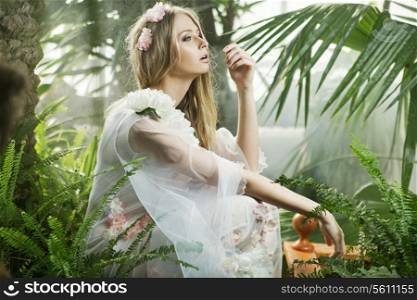 Sensual young woman among the greenery