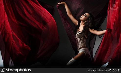Sensual young woman among waving curtains