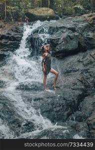 Sensual young woman bathing on the waterfalls