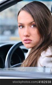 sensual young woman is looking at camera from a car