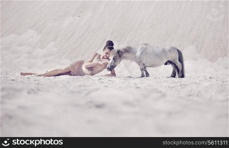 Sensual young woman playing with the pony