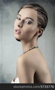sensual young woman posing in romantic beauty portrait with creative plait hairdo, stylish necklace and brilliant make-up
