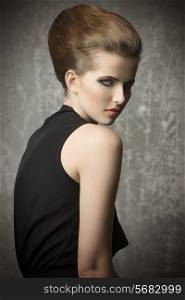 sensual young woman with charming eyes posing with stylish hair-style and make-up, wearing elegant black dress