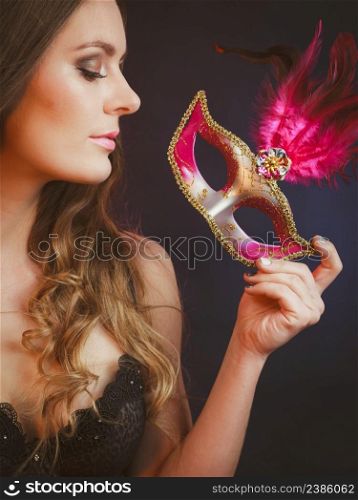 Sensuality celebrations people concept. Sensual lady holding carnival mask. Young woman has amazing and delicate make up.. Sensual lady holding carnival mask.