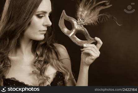 Sensuality celebrations people concept. Sensual lady holding carnival mask. Young woman has amazing and delicate make up.. Sensual lady holding carnival mask.