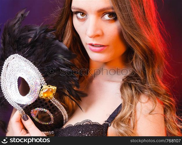 Sensuality celebrations people concept. Sensual lady holding carnival mask. Young woman has amazing and delicate make up.. Sensual lady holding carnival mask.