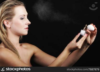 Sensuality concept. Portrait beautiful woman spraying perfume on black background