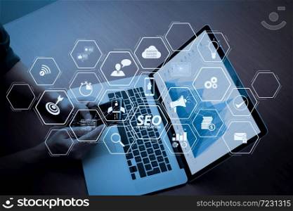 Seo Optimization for website with mobile website and Landing page virtual diagram.Double exposure of businessman hand working with new modern computer and business strategy as concept