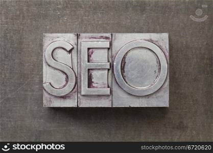 SEO (search engine optimization) acronym - text in vintage letterpress metal type against a grunge steel sheet