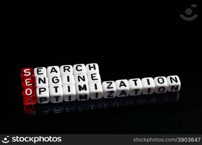 SEO Search Engine Optimization written on dices on black background