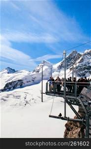 SEP 24, 2013 Jungfrau, Switzerland - Panoramic view of Jungfraujoch peak and tourists at Top of Europe observation deck, snow mountain peak of Switzerland