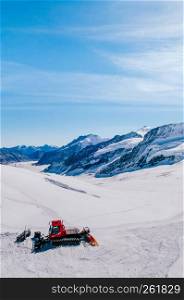 SEP 24, 2013 Jungfraujoch, Switzerland - Snowcat machine to work on a snow field winter landscape of Jungfraujoch, top of Europe Swiss alps scenery.
