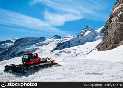 SEP 24, 2013 Jungfraujoch, Switzerland - Snowcat machine to work on a snow field winter landscape of Jungfraujoch, top of Europe Swiss alps scenery.