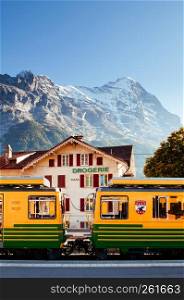 SEP 24,2013 Lauterbrunnen, Switzerland - Yellow Grindelwald train at Kleine Scheidegg station with Tschuggen peak on background, base station for Jungfraujoch