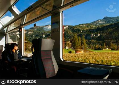 SEP 24,2013 Thun, Switzerland - Tourist enjoy Swiss Alps mountain range with beautiful peaceful scenery and light through train window, Train travel concept image.