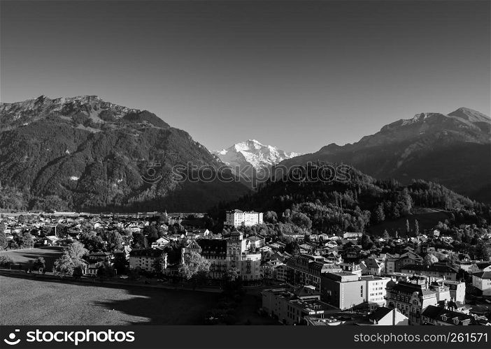 SEP 25, 2013 Interlaken, Switzerland - Evening scene aerial view cityscape vintage Swiss style buildings and Swiss Alps Jungfrau of Interlaken old town area, famous town for tourists