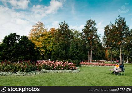 SEP 27, 2013 Bern, Switzerland - European people sit on bench in green beutiful Rosengarten park in early autumn