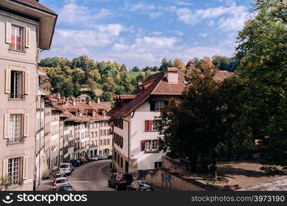 SEP 27, 2103 Bern, Switzerland - Old curvy hill Junkerngasse street with cars and old Swiss style residential buildings in Old town district of Bern