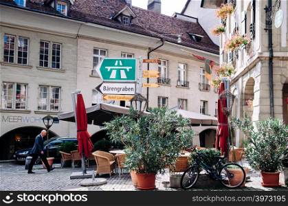SEP 27, 2103 Bern, Switzerland - People walking among vintage historic Swiss style residential buildings with street sign in old town district of Bern