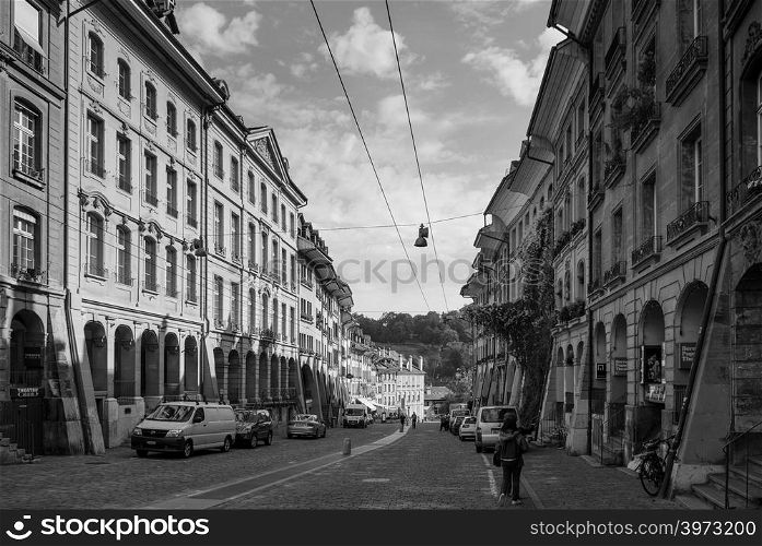 SEP 27, 2103 Bern, Switzerland - People walking among vintage historic Swiss style residential buildings with bright sunlight in old town district of Bern