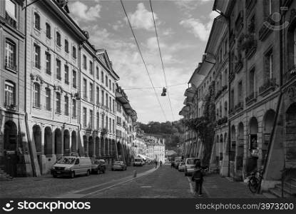 SEP 27, 2103 Bern, Switzerland - People walking among vintage historic Swiss style residential buildings with bright sunlight in old town district of Bern