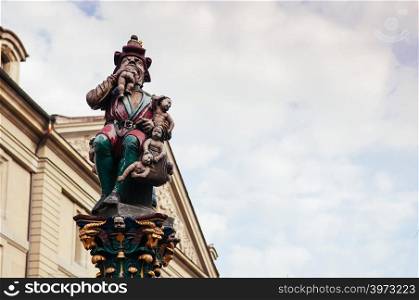 SEP 27, 2103 Bern, Switzerland - scary Child Eater Fountain Kindlifresserbrunnen Fountain statue in old town Bern on marble pillar against the sky