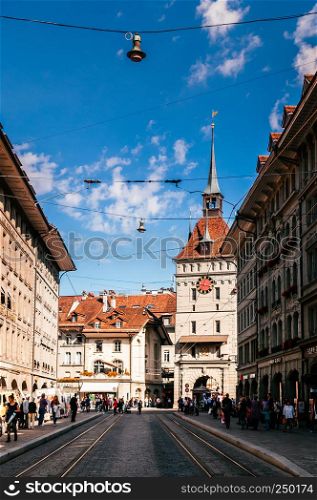 SEP 28, 2013 Bern, Switzerland - Old vintage street scene with tourist walking infront of Kafigturm clock tower. Famous old town area and shopping street