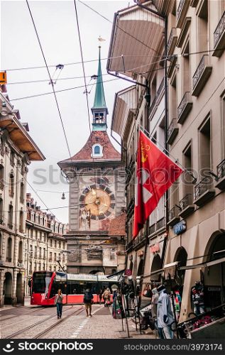 SEP 28, 2013 Bern, Switzerland - Old vintage street scene with tourists and tram running in front of astronomical Zytglogge clock tower. Famous old town area and shopping street