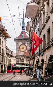 SEP 28, 2013 Bern, Switzerland - Old vintage street scene with tourists and tram running in front of astronomical Zytglogge clock tower. Famous old town area and shopping street