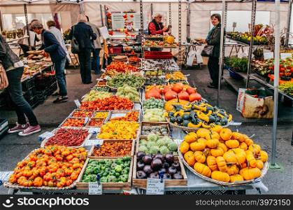 SEP 28, 2013 Bern, Switzerland - Swiss people buying fruit at local Vegetable and fruit shop in morning market Bundesplatz in front of Swiss Parliament building.