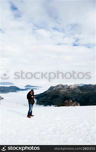 SEP 29, 2013 Engelberg, Switzerland - Tourists walking enjoy wide view of snow slope over cloud and Mountain valley of mount Titlis, famous tourist attraction on Swiss alps.