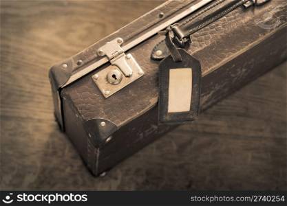 Sepia toned color photo of an old worn suitcase