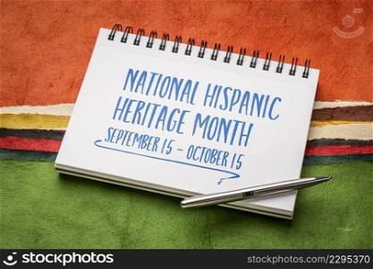 September 15 - October 15, National Hispanic Heritage Month - handwriting in in a spiral notebook against abstract landscape created with Mexican Huun paper, reminder of cultural event