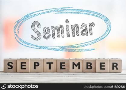 September seminar sign with blue sketch on a wooden stage