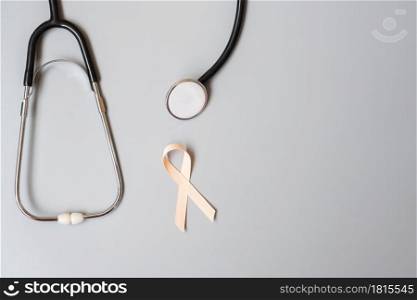 September Uterine Cancer Awareness month, Peach Ribbon with stethoscope for supporting people living and illness. Healthcare and World cancer day concept