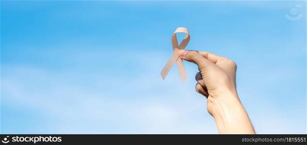 September Uterine Cancer Awareness month, woman hand holding Peach Ribbon for supporting people living and illness. Healthcare and World cancer day concept