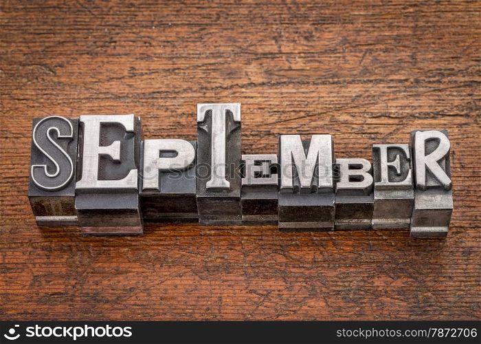 September word in mixed vintage metal type printing blocks over grunge wood