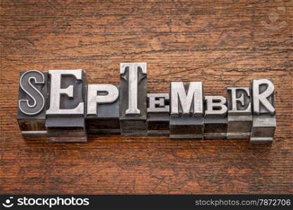 September word in mixed vintage metal type printing blocks over grunge wood