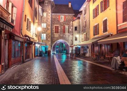 Sepulchre Gate in Old Town of Annecy, France. Gorgeous medieval arch gate Sepulchre Gate on the street Rue Sainte-Claire in Old Town at rainy night, Annecy, France