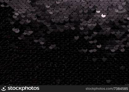 Sequin fabric background. Close-up shot of glittery black sequins texture. Sequin fabric background