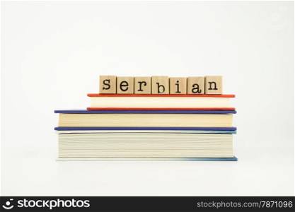 serbian word on wood stamps stack on books, foreign language and translation concept