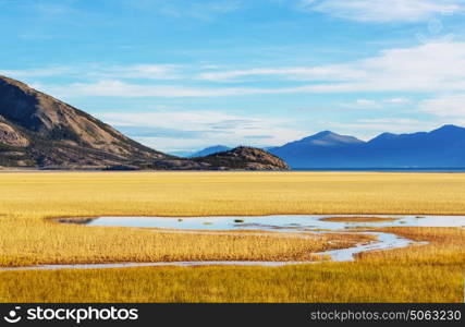 Serene scene by the mountain lake in Canada with reflection of the rocks in the calm water.