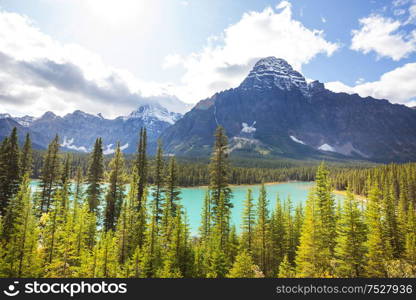 Serene scene by the mountain lake in Canada with reflection of the rocks in the calm water.